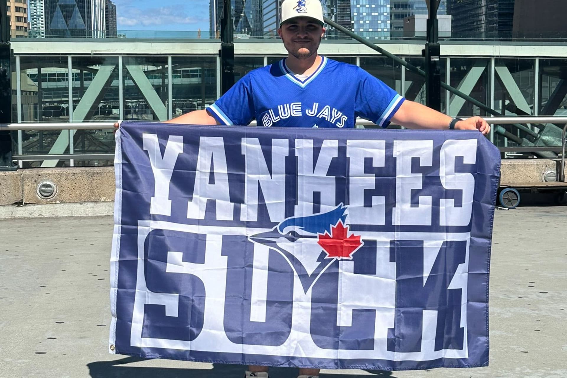 https://display.dailyhive.com/uploads/2025/07/blue-jays-yankees-suck-flag.jpeg